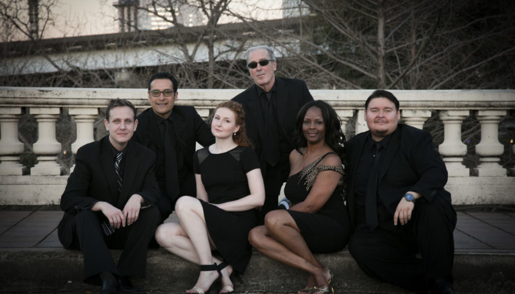 A group of people in black outfits posing for the camera.